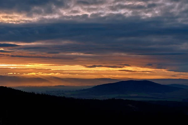 Puesta de sol cielo dramático sobre las montañas forma — Foto de Stock