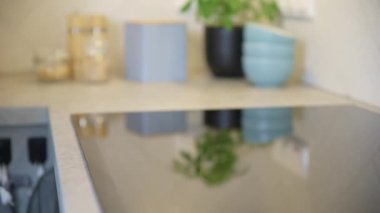 Kadın eli mutfaktaki modern indüksiyon sobasını açıyor.