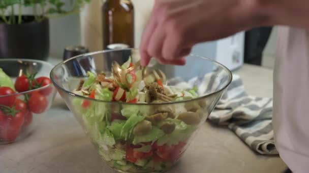Vrouw mengt groene groentesalade in kom in keuken — Stockvideo