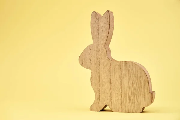 Szczęśliwa dekoracja wielkanocna, drewniany królik na żółtym tle — Zdjęcie stockowe