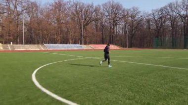 Sporcu adam koşmadan önce ısınma egzersizi yapar.