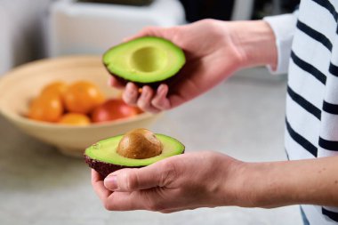 Olgun avokado kadınların elinde, sağlıklı kahvaltı.