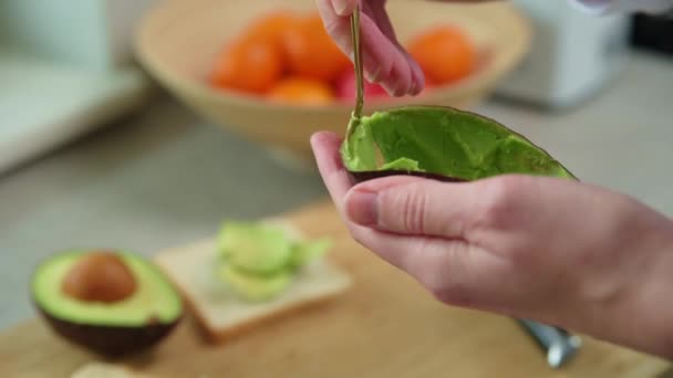 女人手里拿着成熟的鳄梨，健康的早餐 — 图库视频影像