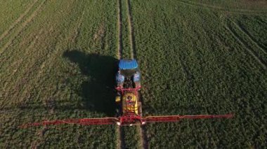 Tarımsal alanda, hava manzarasında traktör spreyi gübresi.