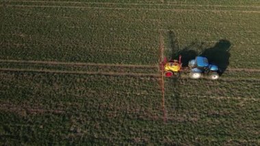 Çiftlik traktörü gübre püskürtür ya da tarım arazisine tarım ilacı sıkarak iyi hasat ve hava manzarası sağlar.