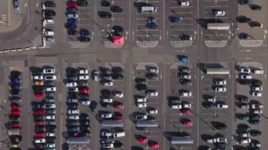 Alışveriş merkezinin yakınındaki otoparkta park edilmiş arabalar.