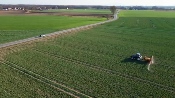 Tractorsproeimeststof op landbouwgebied, vanuit de lucht bekeken — Stockvideo