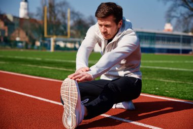 Spor adamı dışarıda koşuya hazırlanıyor.