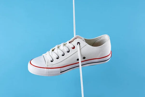 Vita casual sneakers på blå bakgrund, kreativ minimalism — Stockfoto