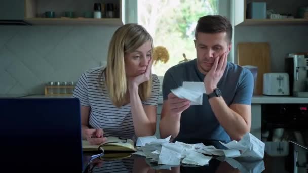 Man and woman looking at payment bills in the kitchen — Stock Video