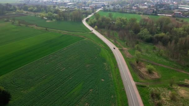 Car driving on road among agricultural fields — Video