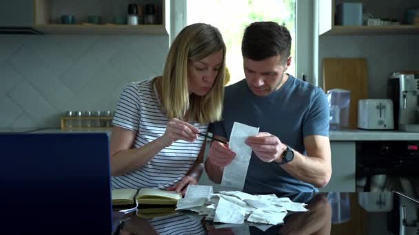 Man and woman looking at payment bills in the kitchen — Stock Video