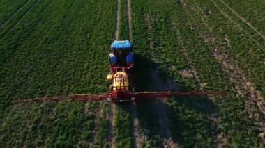 Tarımsal alanda, hava manzarasında traktör spreyi gübresi.