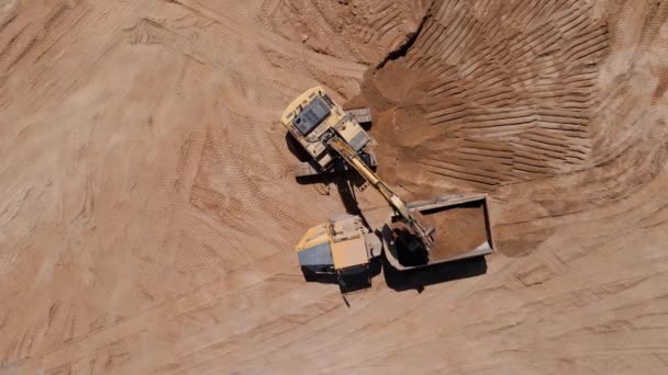 Grävmaskin lastning sand i stor lastbil, antenn vy — Stockvideo