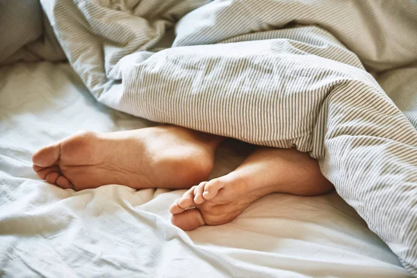 朝のコンセプト 女性はベッドで寝て 毛布の下で裸の女性の足 — ストック写真