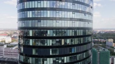 Gökdelen pencereleri üzerinde İHA uçuşu. Modern ofis binası, hava manzaralı. İş merkezi cam cepheli şehir manzarası