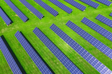 Yeşil alanda güneş panelleri bataryası, hava manzarası. Yenilenebilir enerji için fotovoltaik modüller. Temiz, sürdürülebilir, alternatif enerji kavramı