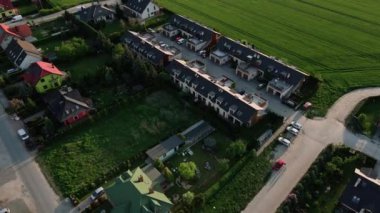 Aile evleri olan Avrupa banliyölerinin, gün batımında Avrupa 'nın küçük bir kasabasında binaların ve sokakların olduğu yerleşim yerlerinin hava aracı görüntüsü