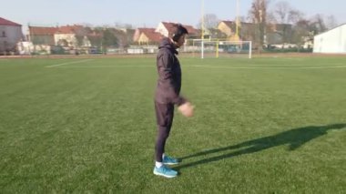 Spor ayakkabılı adam dışarıda koşmadan önce ısınma egzersizi yapıyor.