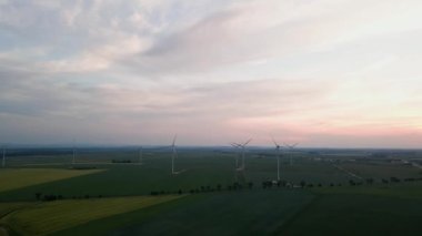 Yel değirmeni türbin jeneratörünün temiz, yenilenebilir, sürdürülebilir alternatif enerji kavramı kırsal alanda güzel günbatımı gökyüzüne karşı havadan görüntüsü