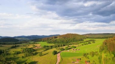Gün batımındaki güzel manzara, köy ve dağlara yakın yeşil tarlaları olan kırsal alan manzarası.