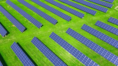 Yeşil alanda güneş panelleri bataryası, hava manzarası. Yenilenebilir enerji için fotovoltaik modüller. Temiz, sürdürülebilir, alternatif enerji kavramı