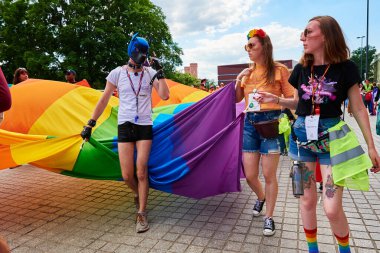 İnsanlar LGBTQ gökkuşağı bayrağıyla gurur yürüyüşüne akın ediyor. Hoşgörü, çeşitlilik ve cinsiyet kimlik kavramı. Wroclaw, Polonya - 11 Haziran 2022