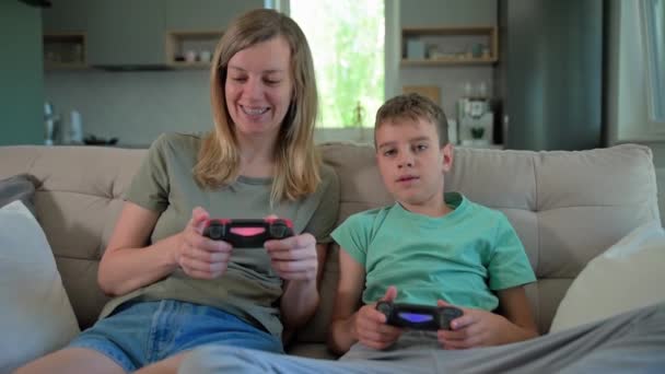 息子と母親が自宅でビデオゲームをプレイ 家族で一緒に時間を過ごす 幸せな関係 オンラインエンターテイメントとレジャー活動 — ストック動画