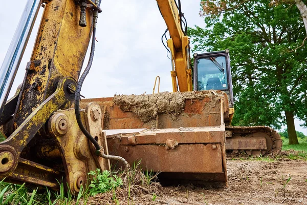 İnşaat alanındaki sarı kazıcı, toprak kazan ağır inşaat makinesi, toprak toprağında çalışan Crawler kepçesi.