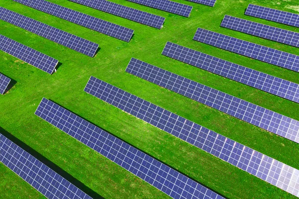 Solar panels battery in green field, aerial view. Photovoltaic modules for renewable energy. Concept of clean, sustainable, alternative energy