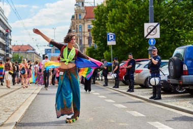 Kadın paten gösterisinde polisin yanındaki caddede. Gurur yürüyüşünde LGBTQ bayrakları olan insanlar. Hoşgörü, çeşitlilik ve cinsiyet kimlik kavramı. Wroclaw, Polonya - 11 Haziran 2022