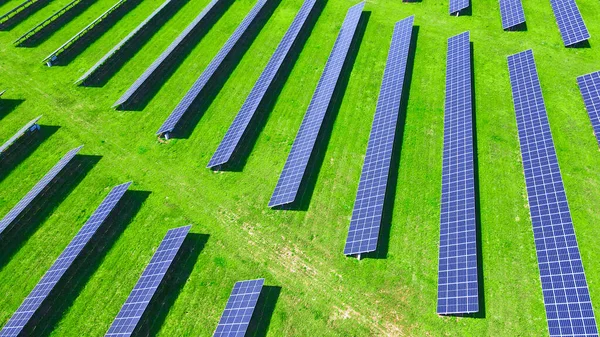 Yeşil alanda güneş panelleri bataryası, hava manzarası. Yenilenebilir enerji için fotovoltaik modüller. Temiz, sürdürülebilir, alternatif enerji kavramı