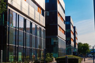 Yeşil ağaçlarla dolup taşma cephesi, iş dünyası için modern ofis binası, ikametgah çağdaş