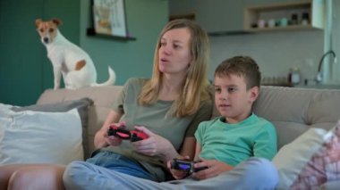 Oğlan ve anne evde video oyunu oynuyor, aile birlikte vakit geçiriyor, mutlu bir ilişki, online eğlence ve boş zaman aktivitesi.,