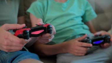 Oğlan ve anne evde video oyunu oynuyor, aile birlikte vakit geçiriyor, mutlu bir ilişki, online eğlence ve boş zaman aktivitesi.,