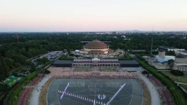 İnsanlar Polonya 'nın Wroclaw şehrindeki Hala Stulecia' da multimedya çeşmesinin yanında dinleniyorlar. Centennial Hall, UNESCO Dünya Mirası Alanına sahip şehir manzarası