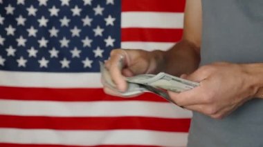 Male hands counting 100 usd banknotes agains american flag, Unrecognizable man calculating cash dollars