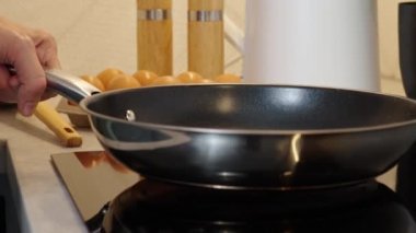 Modern mutfak aletleri, indüksiyon sobasını çelik tavayla açmak, parmak sensör düğmesine basmak, indüksiyon ya da elektrikli hob.
