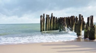 Baltic sea seachore with waves, breakwater and beautiful cloudy sky without people, Summer travel and vacation in Poland