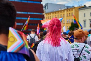 People crowd with LGBTQ rainbow flags on pride parade. Tolerance, diversity and gender identity concept