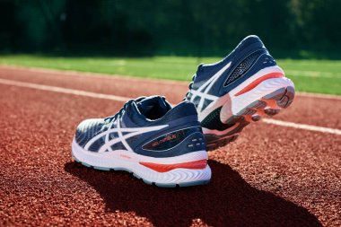 Asics Gel Nimbus running shoes at stadium track, Pair of Asics sport sneakers for jogging. Katy Wroclawskie, Poland - August 07, 2022