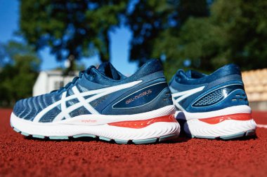 Asics Gel Nimbus running shoes at stadium track, Pair of Asics sport sneakers for jogging. Katy Wroclawskie, Poland - August 07, 2022