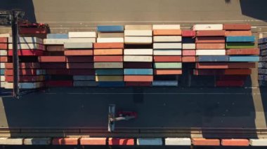 Process of loading MAERSK containers in terminal, Unloading containers in warehouse on railroad platform with cranes and forklifts, aerial view