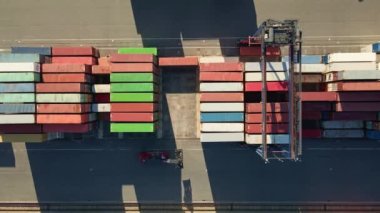 Process of loading MAERSK containers in terminal, Unloading containers in warehouse on railroad platform with cranes and forklifts, aerial view