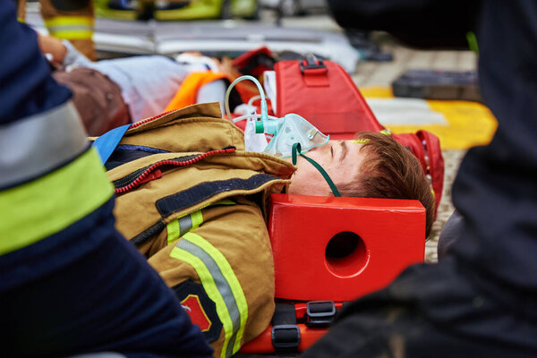 Rescuers provide first aid to the victim during a car accident. Person injured in the accident is lying on the road. Katy Wroclawskie, Poland - May 28, 2022