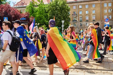People crowd have fun at gay pride parade with rainbow flags, March on city street in support of LGBT community. Wroclaw, Poland - June 11, 2022