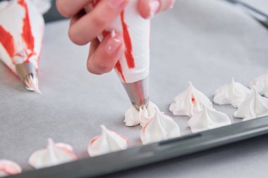 Process of making homemade meringue, woman cooking sweet cream for dessert on baking sheet