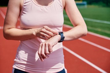 Woman use fitness watch before cardio exercises, Checking results on smart watch after training, Healthy lifestyle concept
