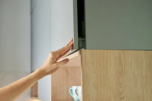 Female Hand Open Kitchen Cabinet Cupboard Door Kitchen Furniture — стоковое фото