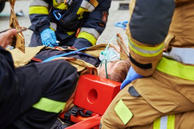 Rescuers provide first aid to the victim during a car accident. Person injured in the accident is lying on the road. Katy Wroclawskie, Poland - May 28, 2022